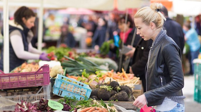 Woman at a market buying fruit and veg