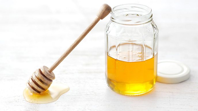 A pot of honey with a dipper