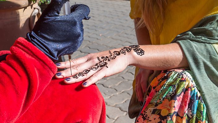 Black henna being applied