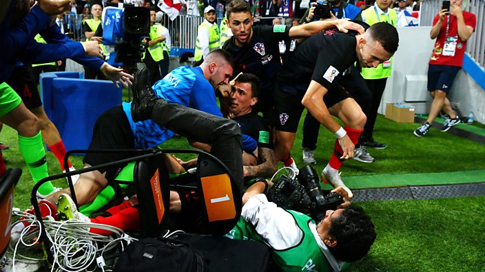 Croatian players pile on top of a photographer