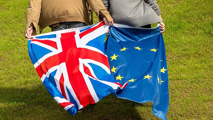 Two young people – one holding the Union flag and the other holding the EU flag