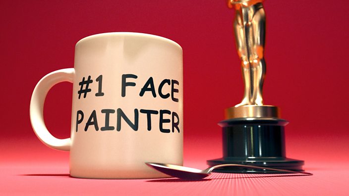 A mug with the words #1 face painter on the side stood next to an oscars award trophy