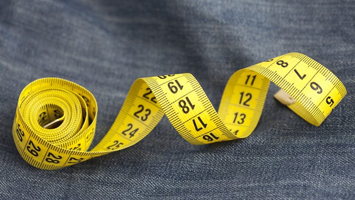 A measuring tape on a pair of jeans