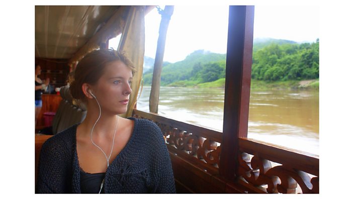 Photo of Scarlett looking out at the water from a boat, with her headphones on