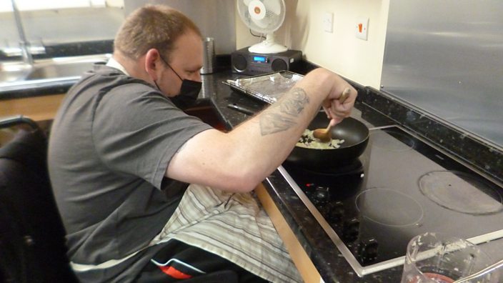 William in a wheelchair cooking on a hob