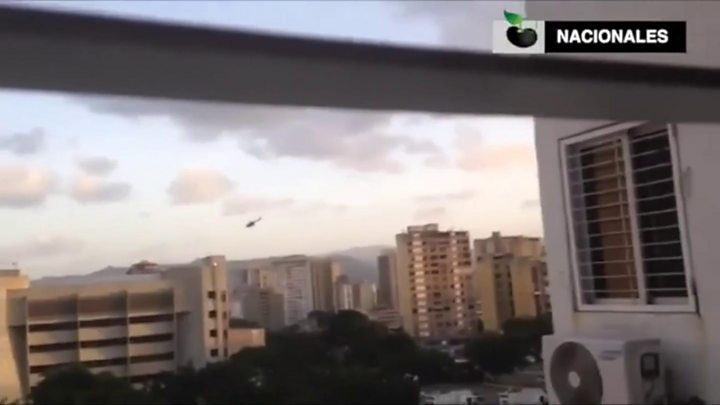 The helicopter circles buildings before gunshots and a bang are heard