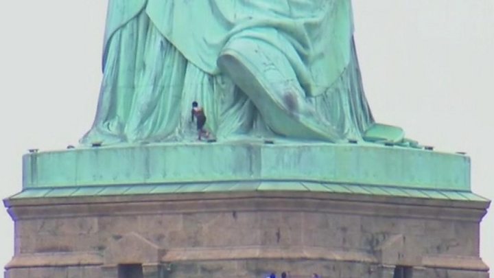 Person Climbs To Statue Of Liberty Base - 