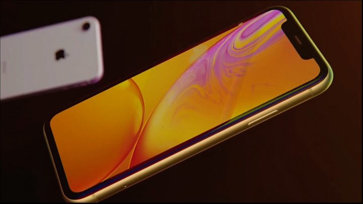 Two new mobile phones, one gold displaying a liquid gold and pink homescreen.