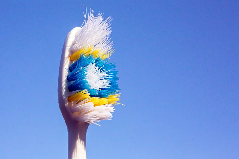 Close up picture of a fraying toothbrush head with a blue background (Credit: Getty Images)