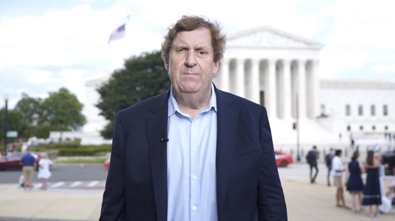 A man stands in front of the Supreme Court