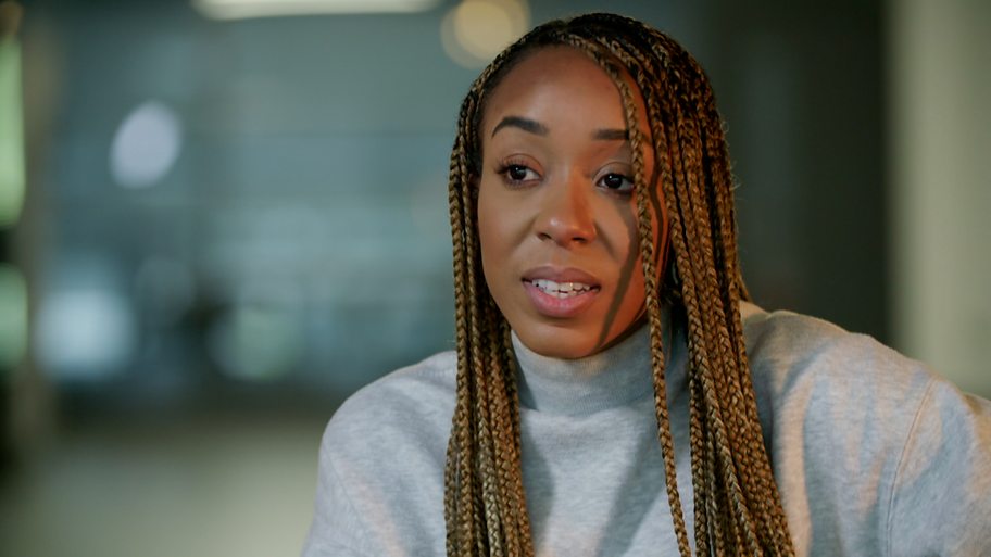 A young black woman speaks to someone off camera