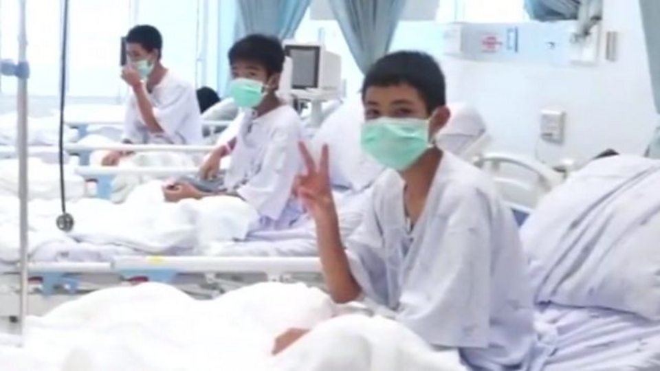 The boys give peace signs as they recover in hospital