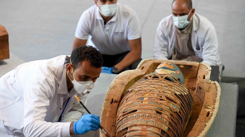 Archeologen openen een kist om een mummie te onthullen, van meer dan 2500 jaar geleden