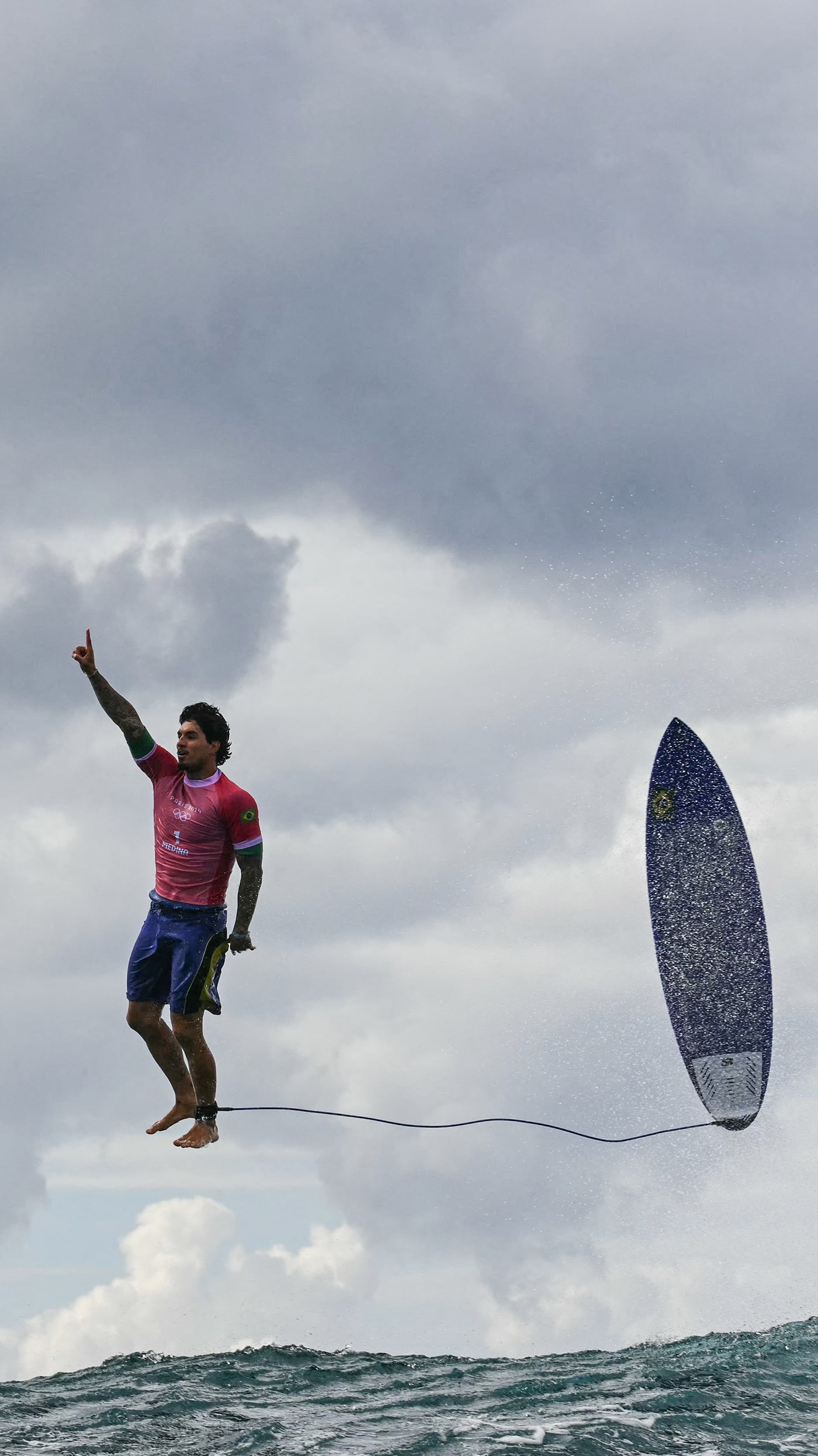 Brazil's Gabriel Medina caught in mid air reacting after getting a large wave in the 5th heat of the men's surfing