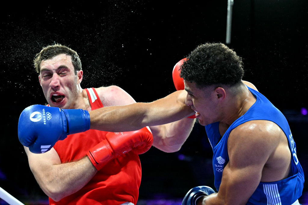 Armenia's Davit Chaloyan takes a punch from Britain's Delicious Orie in a boxing match 