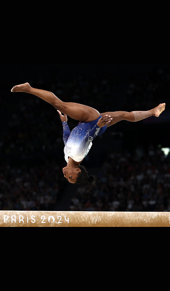 Simone Biles is captured upside-down while performing a somersault during the final of the women's individual beam.