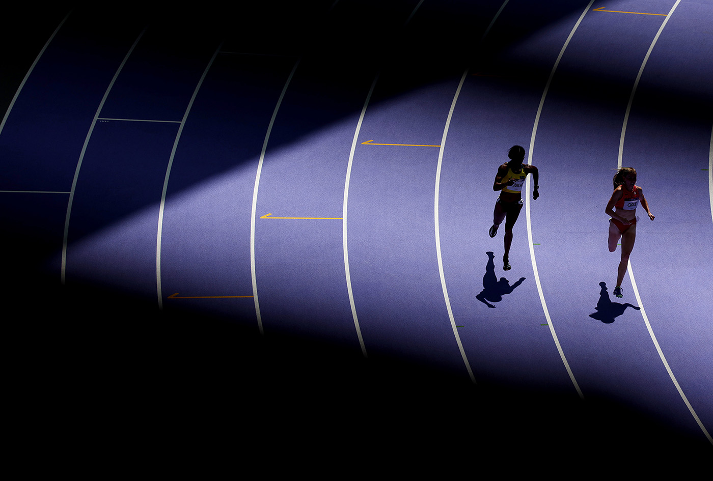 A sunbeam illuminates Evelis Aguilar of Team Colombia and Lauren Gale of Team Canada as they compete during the Women's 400m Round 1