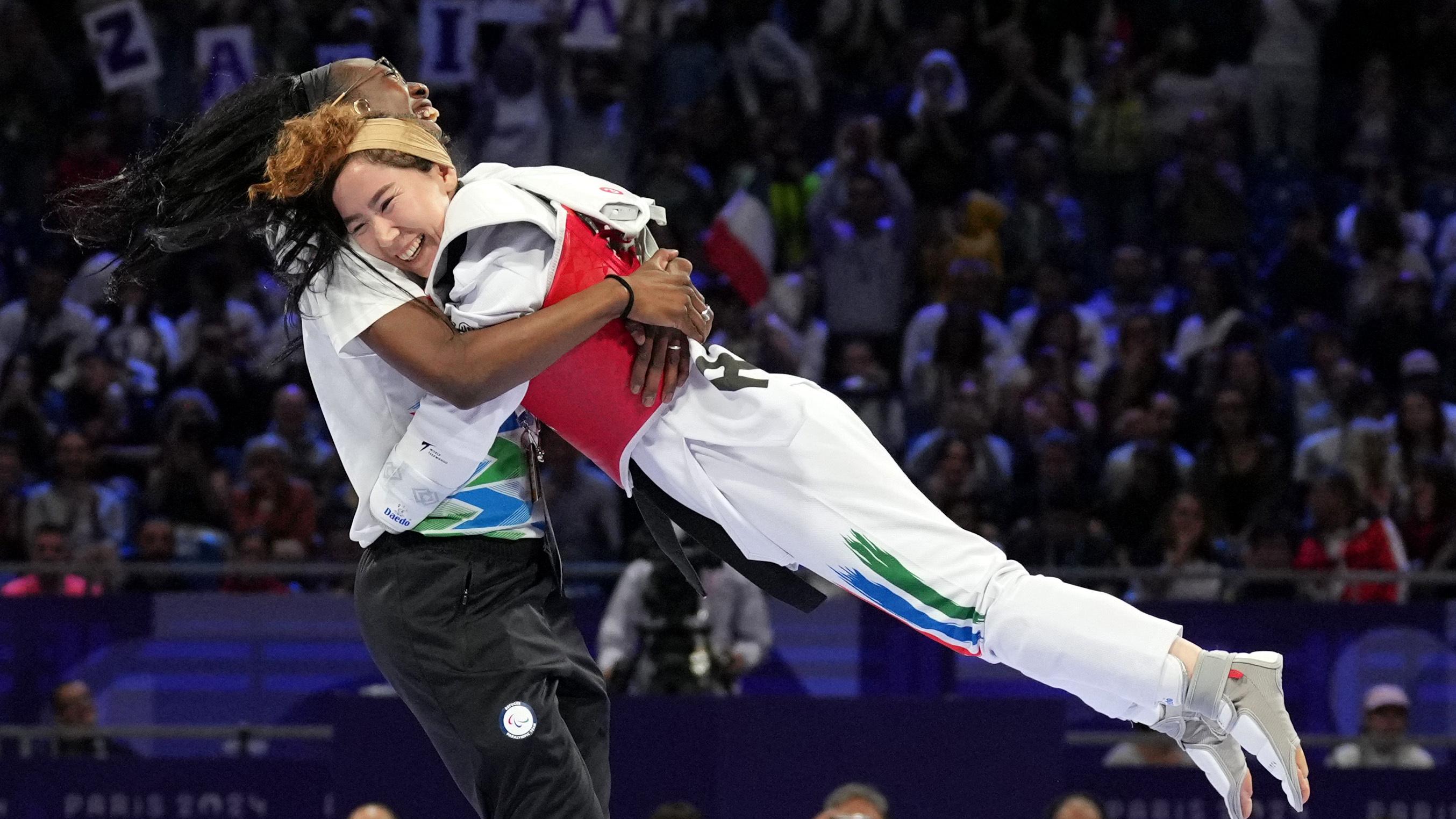 Zakia Khudadadi célèbre avec son entraîneur après avoir été déclarée gagnante de la finale de taekwondo