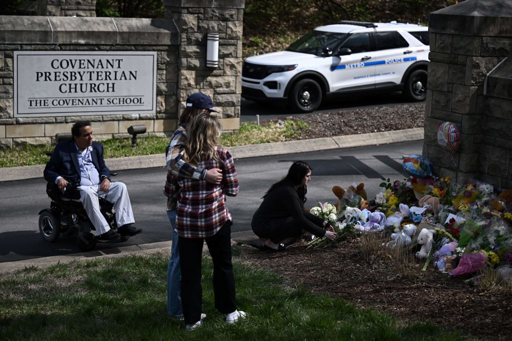 People pay their respects at a makeshift memorial for victims at the Covenant School building at the Covenant Presbyterian Church following a shooting in Nashville, Tennessee, on March 28, 2023.