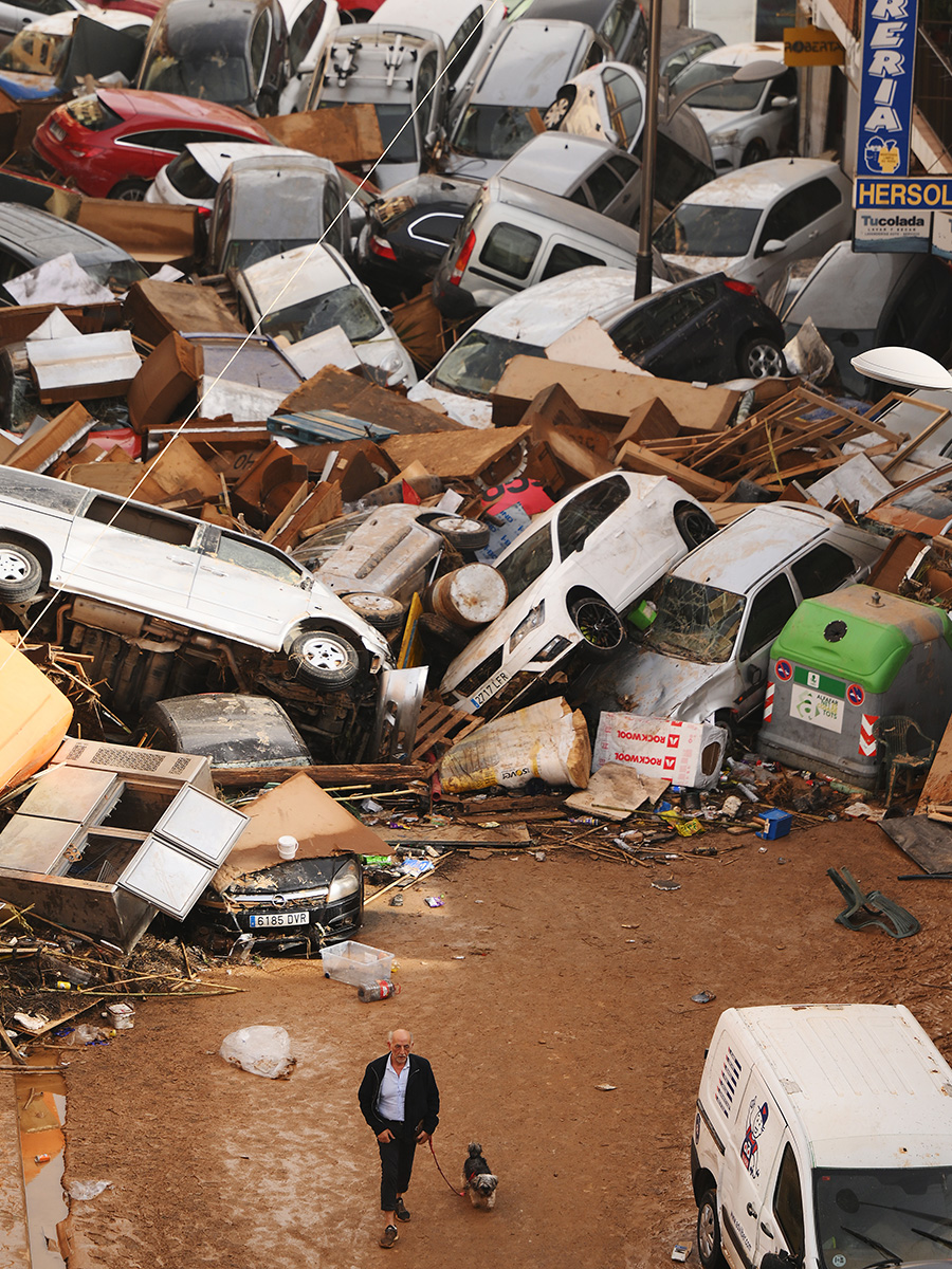 Man walks past debris in Sedaví, near Valencia