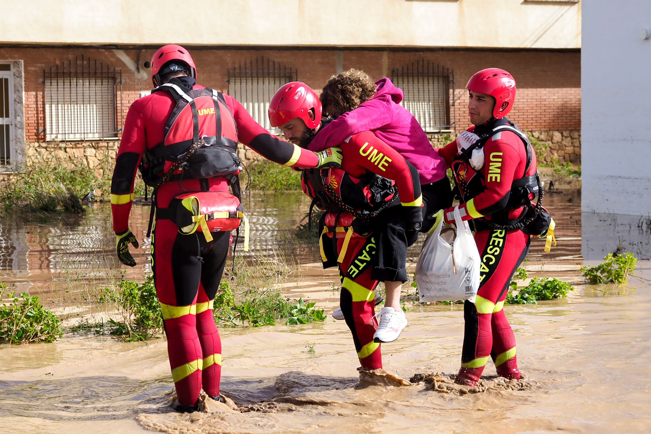 Members of the Spanish Emergency Military Unit (UME) help a resident in the flood-hit municipality of Mira