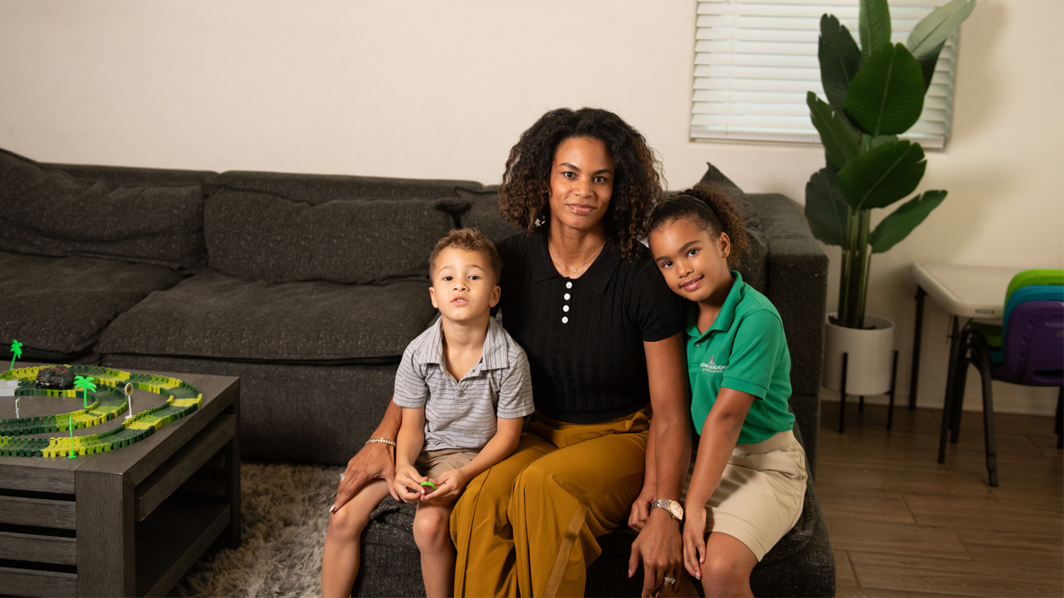 Allison McCullough sits in her living room with her son and her daughter by her side.