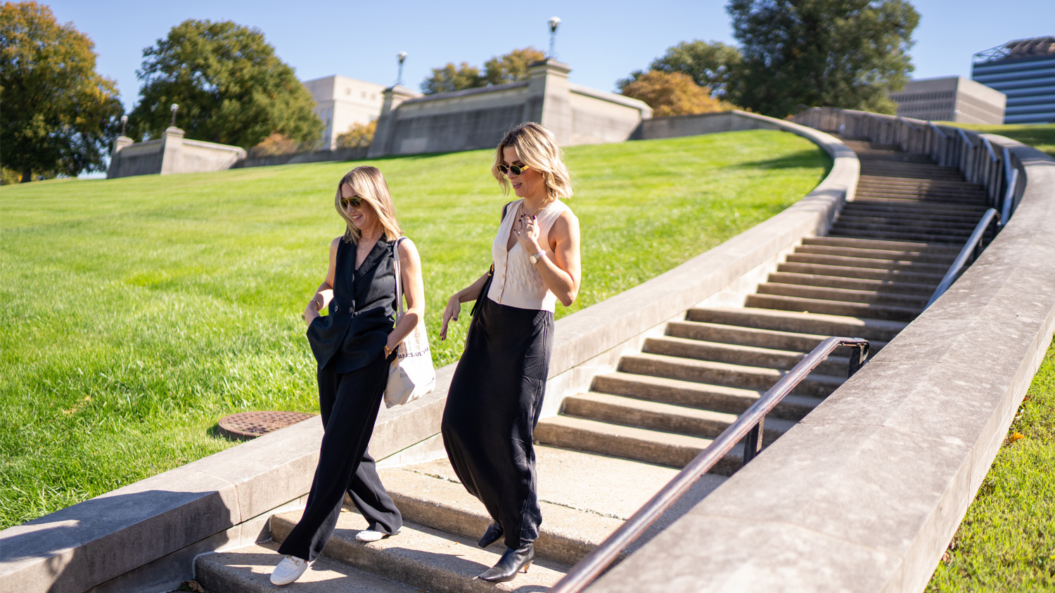 Melissa Alexander and Mary Joyce talk and smile as they come down the stairs together.