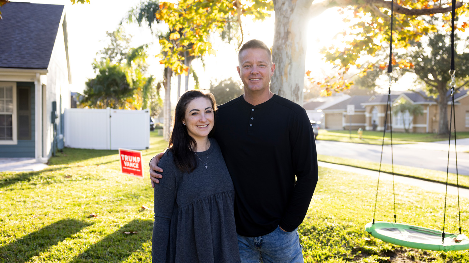 Craig and Brianna blessing pose in front of their house in Orlando, Florida