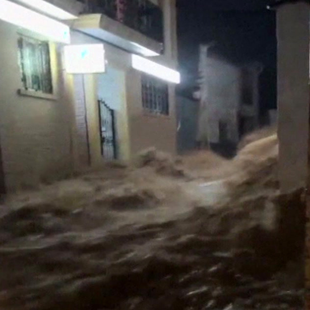 Torrents of water wash down a street like a river