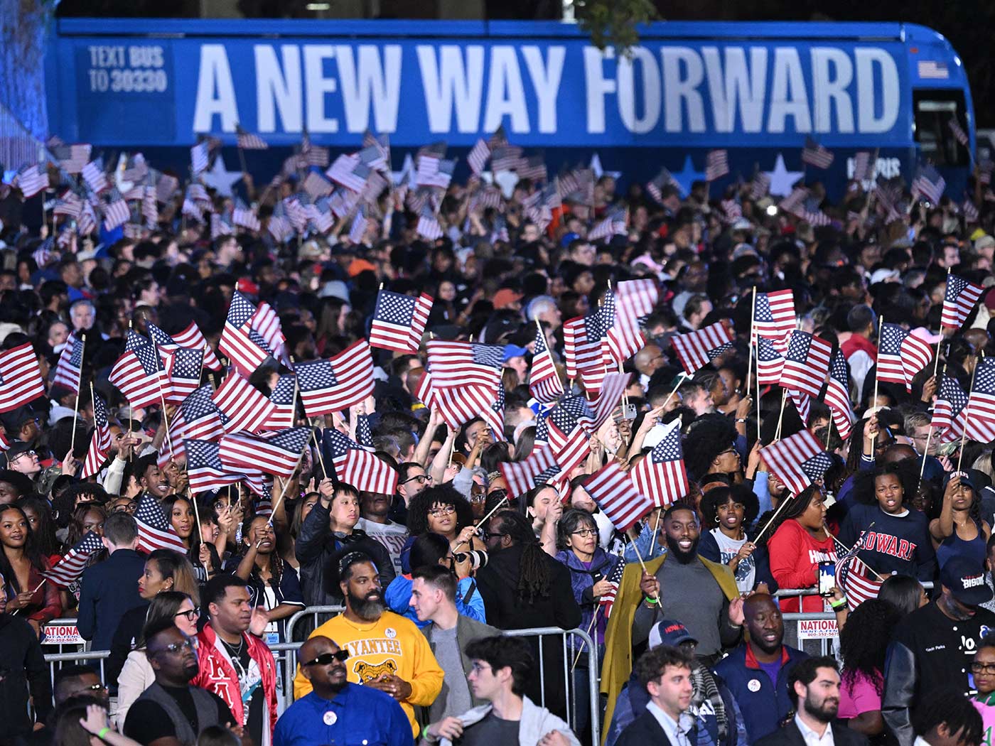 Supporters of Kamala Harris wave flags at the start of an election night party in Washington DC (Saul Loeb/AFP)