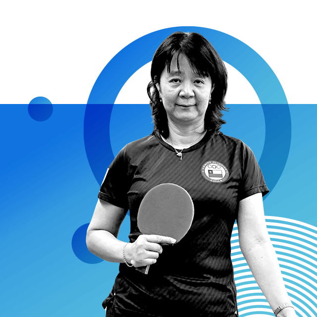 Table tennis player Zhiying Zeng wearing a T-shirt with a logo of the Chilean flag and Olympic rings on it, holding a table tennis bat in front of her.