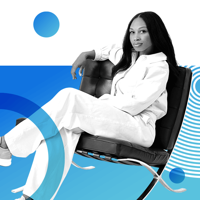 Olympian Allyson Felix in a white jumpsuit, looking relaxed to the camera while sitting with her legs crossed on a mid-century style leather armchair.