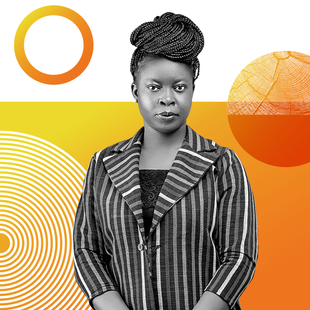 Climate justice advocate Adenike Oladosu is wearing a striped blazer and standing to face the camera with her dark braided hair tied up on top of her head.