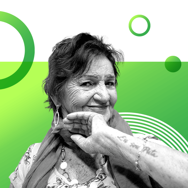 Campaigner Lourdes Barreto poses with her left hand up to the right side of her face, covering her chin. Her forearm shows a tattoo of letters and she wears a bracelet. Barreto looks at the camera with a smile, as she wears large, dangling earrings and a necklace.