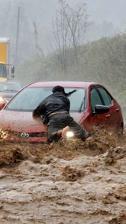 A local resident helps free a car that became stranded in a stretch of flooding road as Tropical Storm Helene strikes, on the outskirts of Boone, North Carolina, USA 27 September 2024.