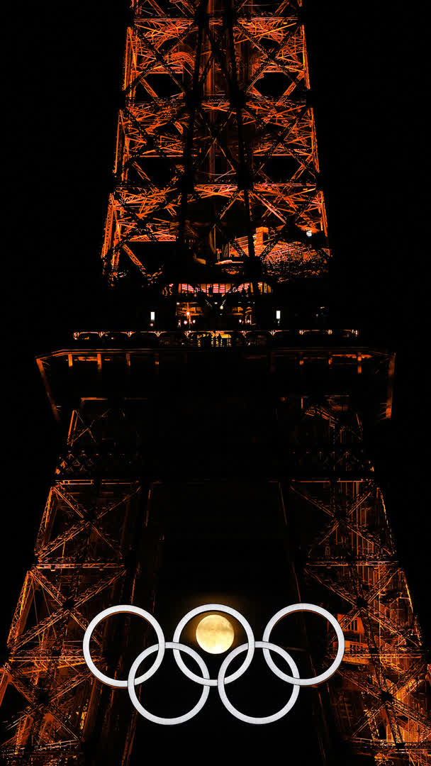 The moon is pictured with the Olympic cauldron and the Eiffel Tower