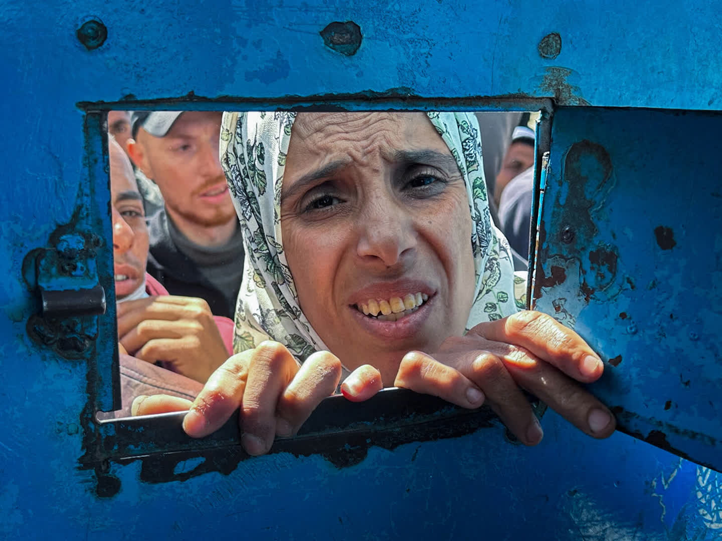 A Palestinian woman waits to receive aid from a UNRWA distribution centre which was hit in an Israeli strike in Rafah, in the southern Gaza Strip 13 March.