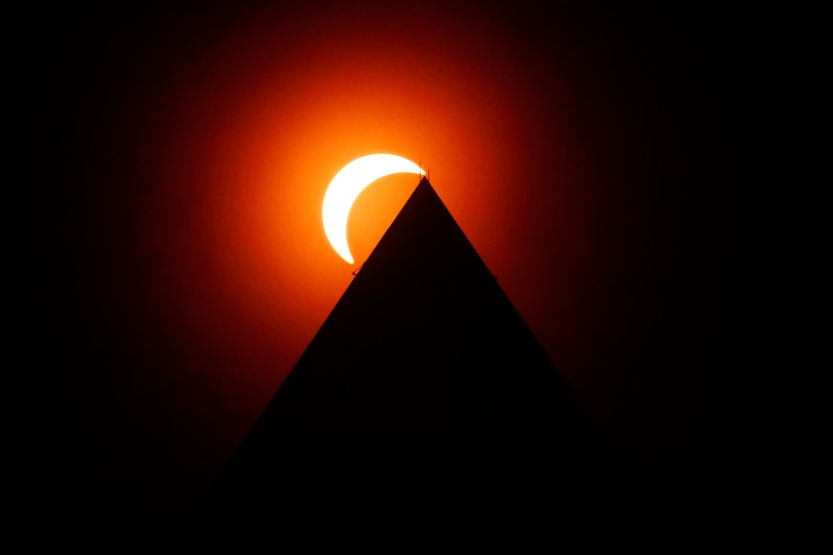 The solar eclipse is seen above the Washington Monument, 8 April 2024