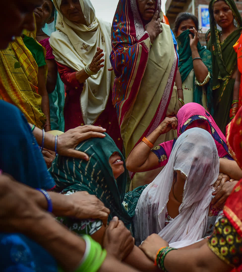 Relatives mourn outside of the home of three victims of same family who died in a stampede on July 03, 2024 in Sokna village in Hathras, India.