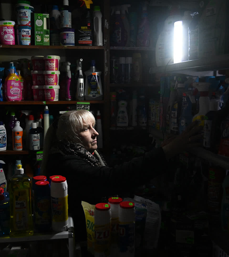 A woman in a shop during a partial blackout in Lviv on November 28, 2024, following Russian strikes on Ukrainian energy infrastructure,