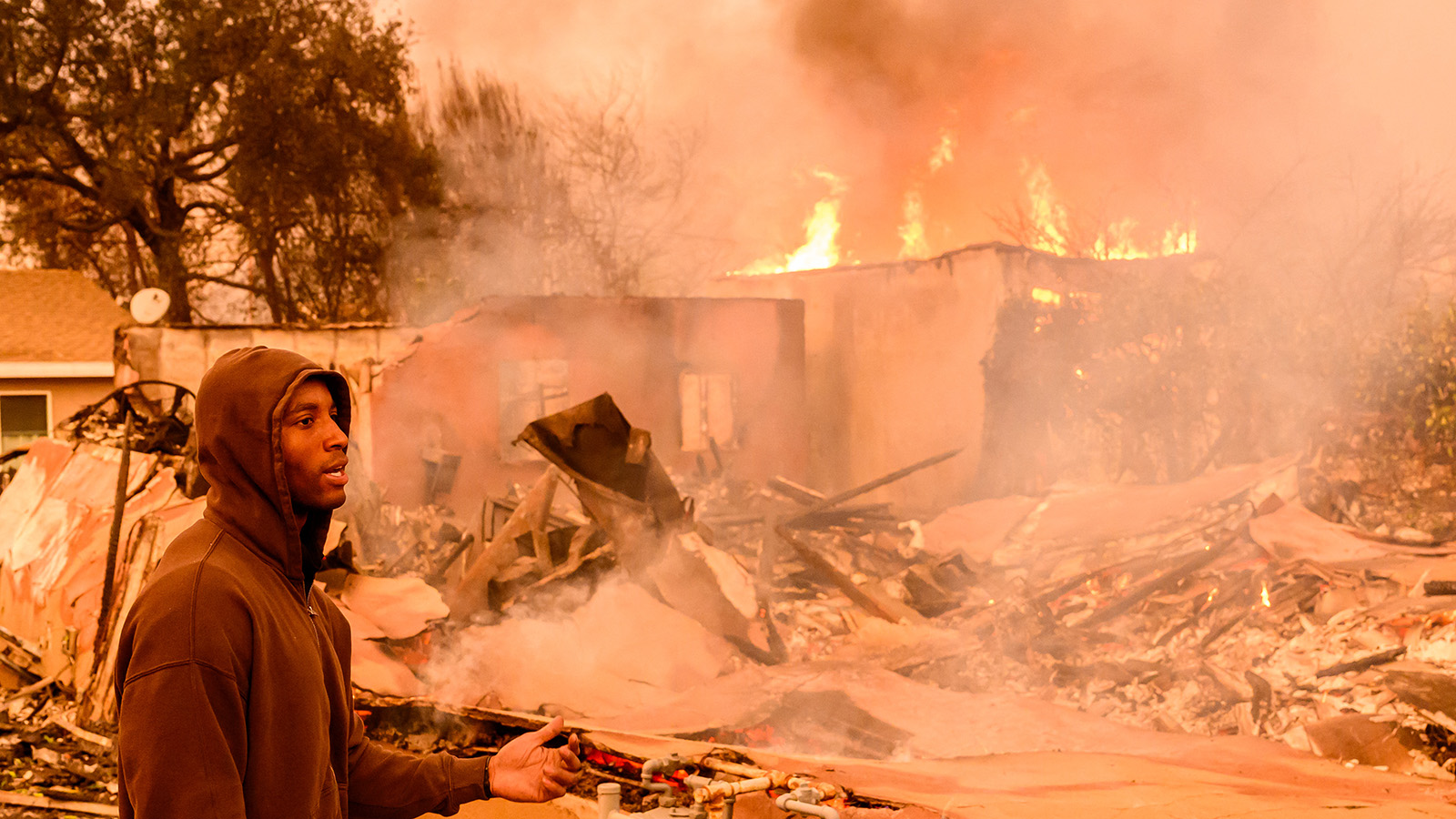 A resident views his property as it burns during the Eaton fire in the Altadena area of Los Angeles