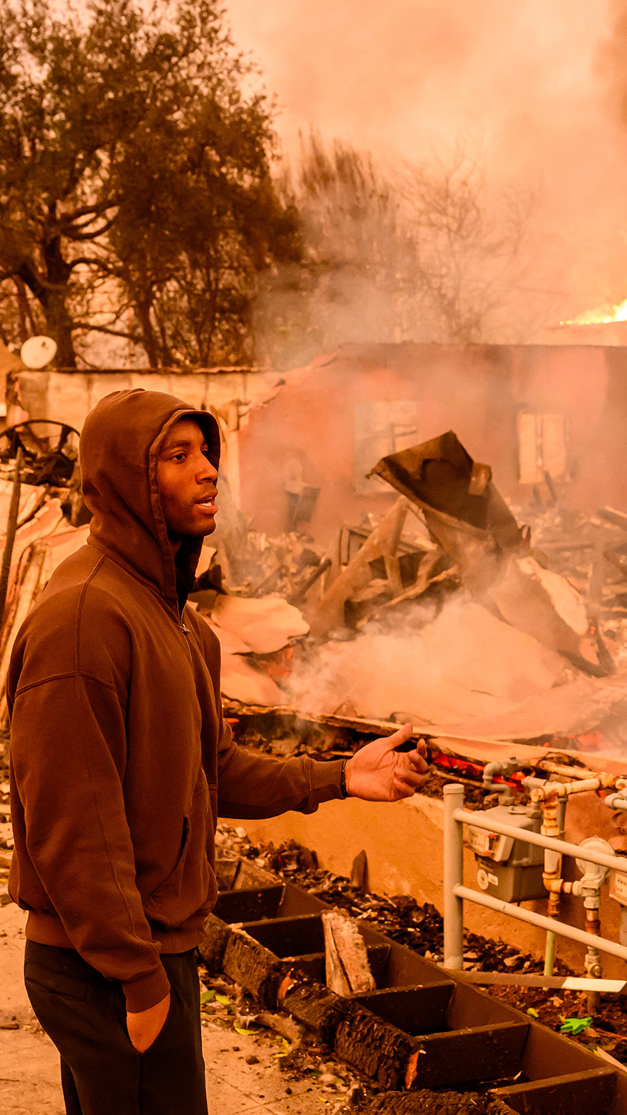 A resident views his property as it burns during the Eaton fire in the Altadena area of Los Angeles