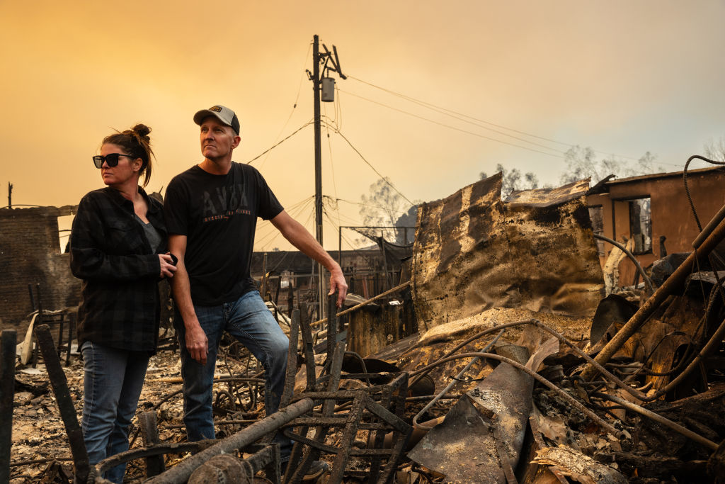 A couple surveys the ruins of their business, the Rancho Bar, which was destroyed by the Eaton Fire in Altadena, California, on January 9, 2025