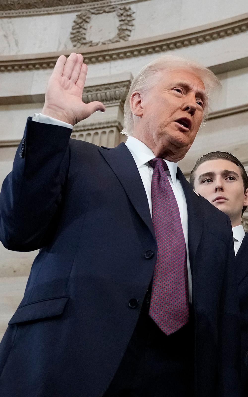 President Donald Trump takes the oath of office from Chief Justice John Roberts as Barron and Melania look on