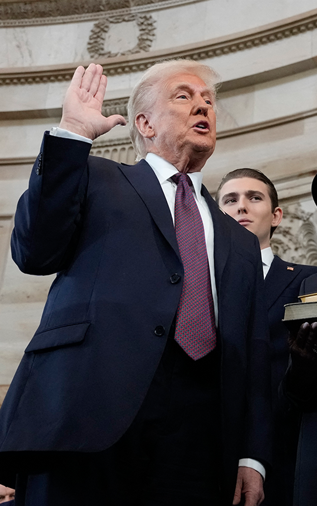 US President Donald Trump takes the oath of office from Chief Justice John Roberts as Melania Trump looks on during inauguration ceremonies in the Rotunda of the US Capitol on 20  January, 2025 in Washington, DC