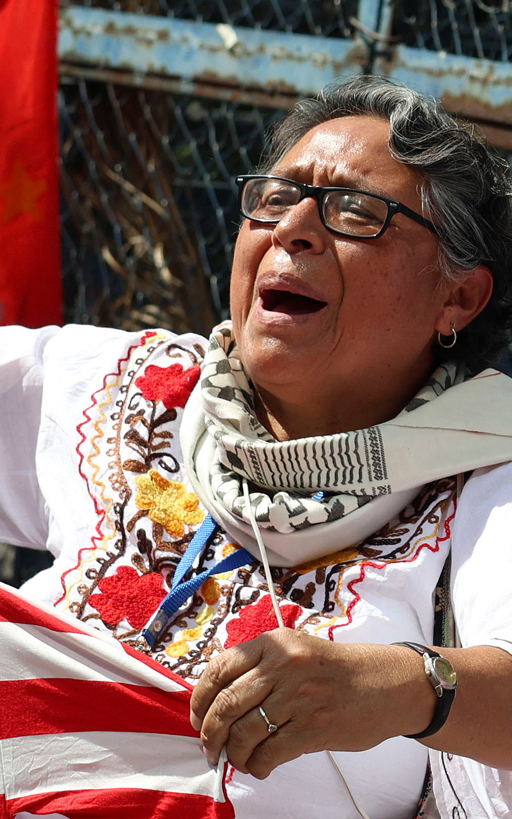 A woman holds an US flag stained with red paint during a protest outside the US embassy in Mexico