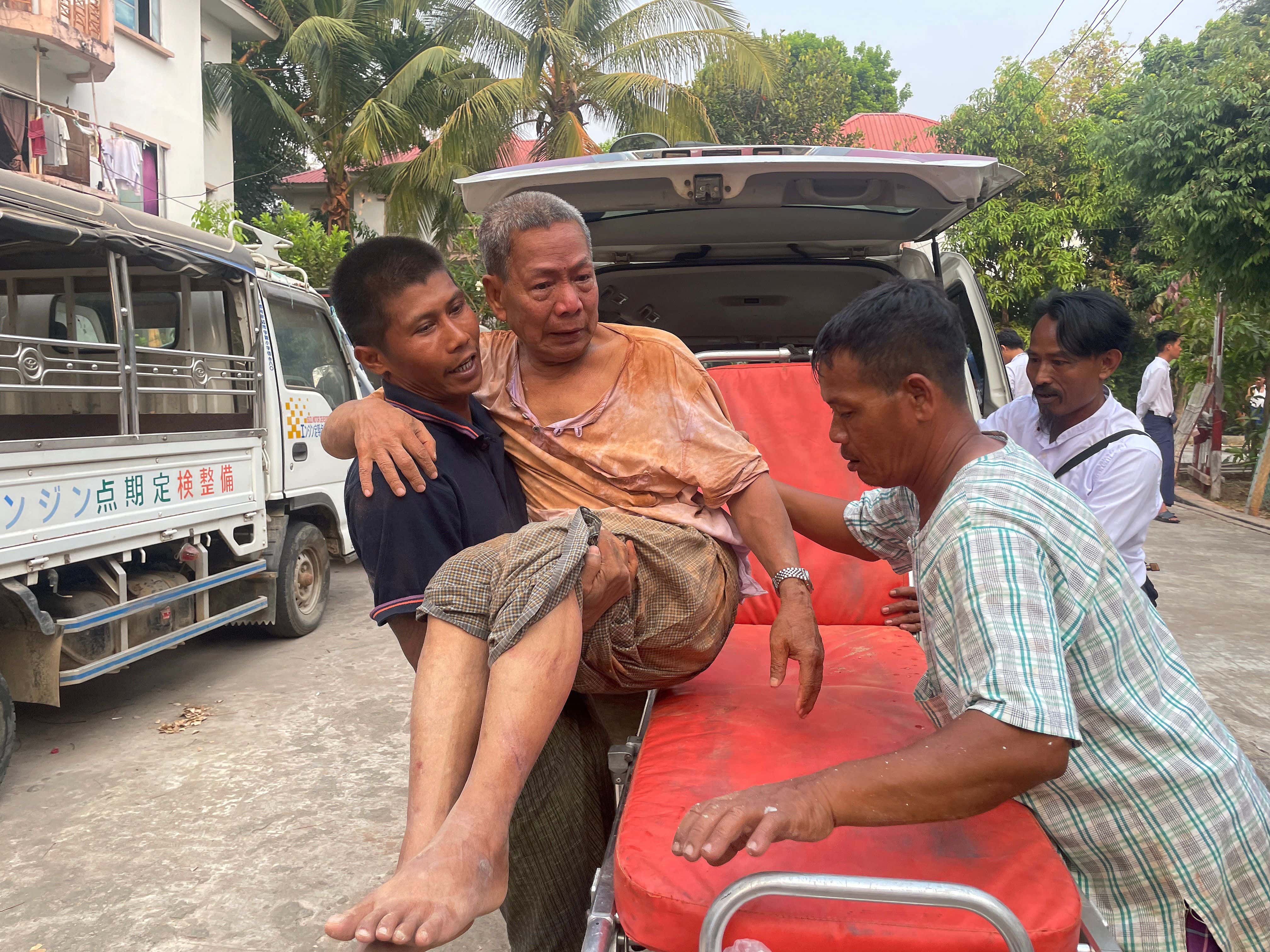 An injured person is carried to a stretcher as rescuers search for survivors in damaged government staff housing buildings following an earthquake in Nay Pyi Daw, Myanmar
