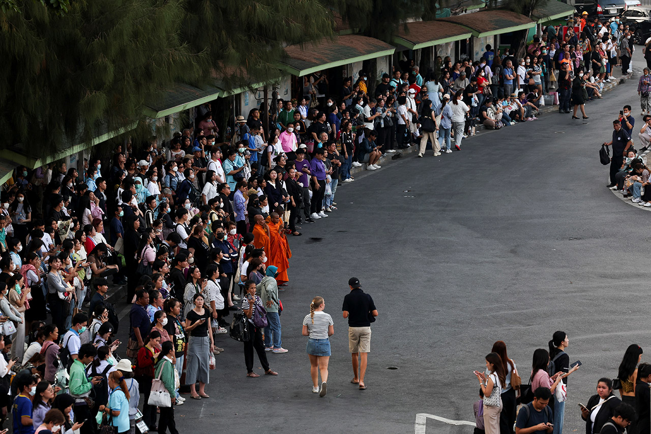 People wait at a bus stop after a strong earthquake in Bangkok, Thailand