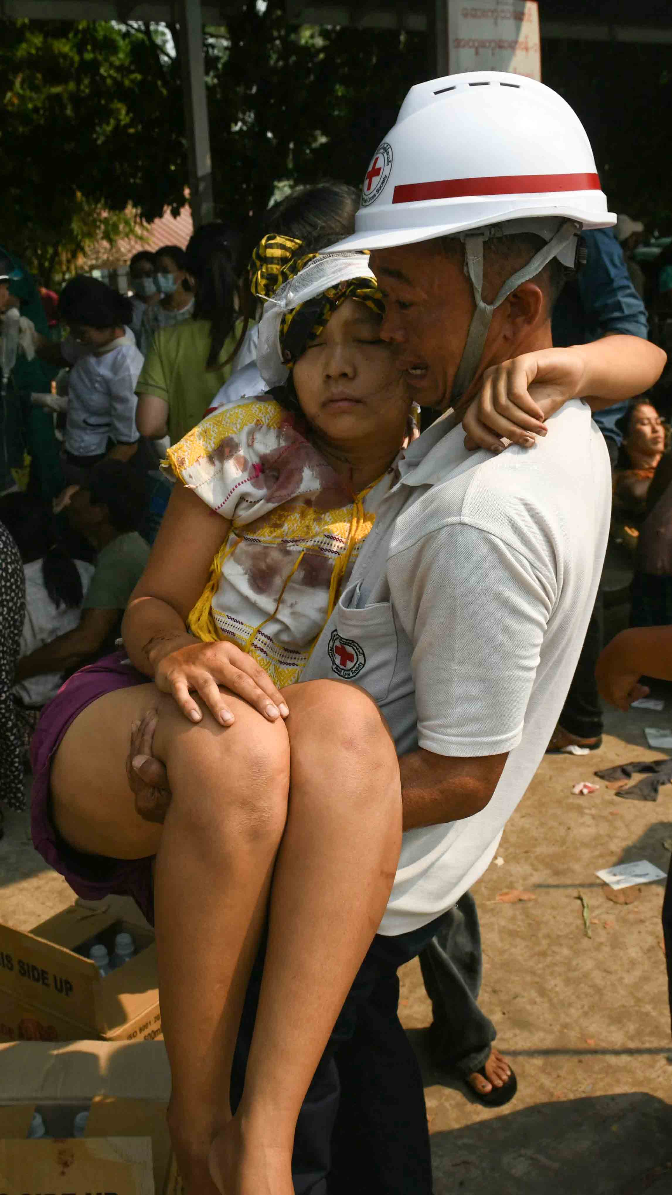 An earthquake survivor is carried as she waits to receive medical attention at a hospital in Nay Pyi Daw on March 28, 2025, after an earthquake in central Myanmar.