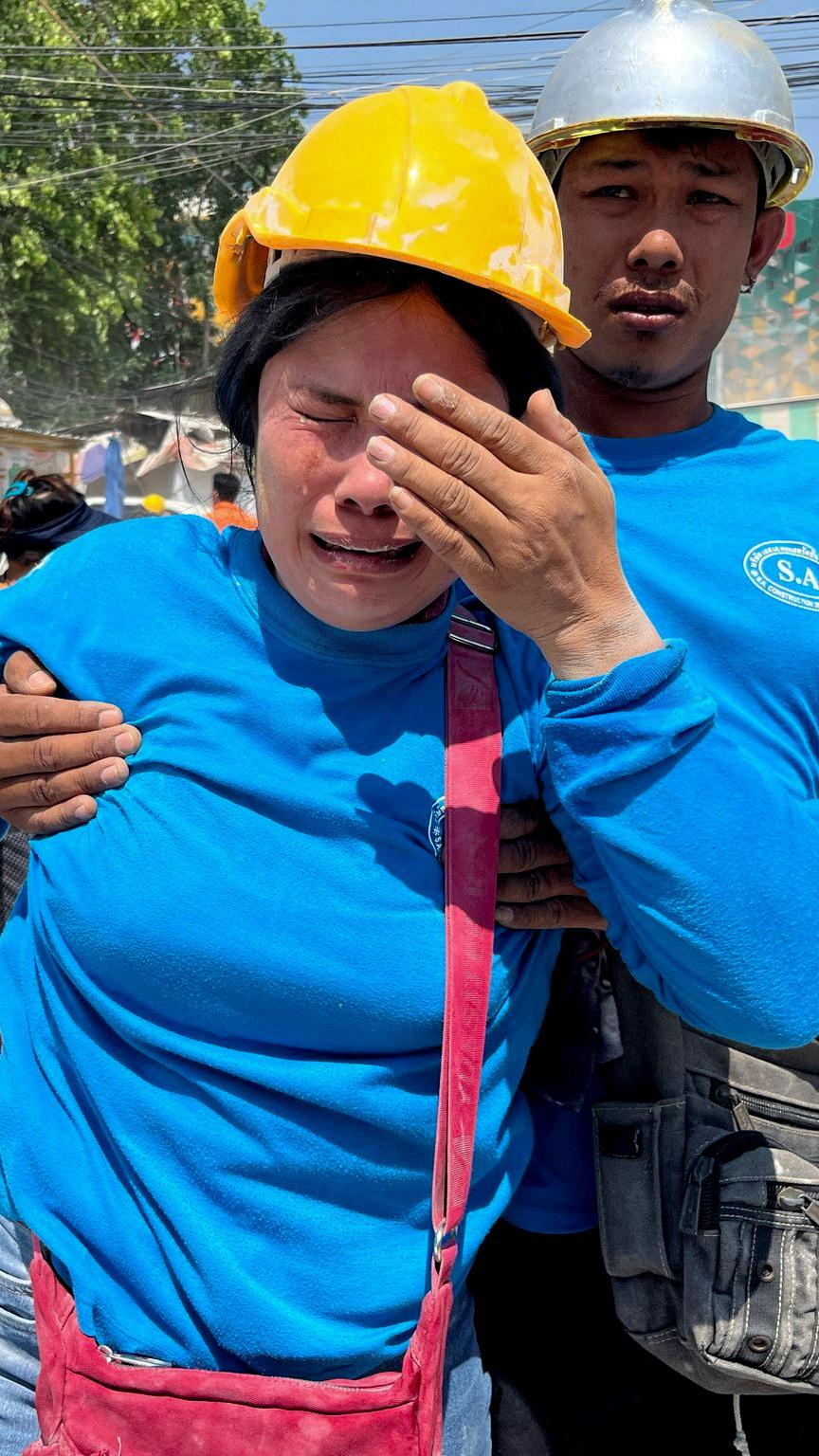 A worker cries near a site of a collapsed building in Bangkok, Thailand, after the tremors of a strong earthquake